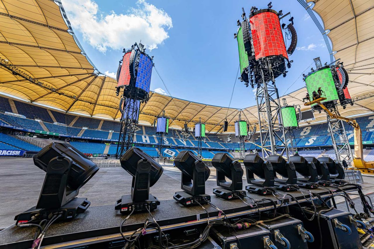 Rows of lighting fixtures and tall video towers in the M72 stadium setup.