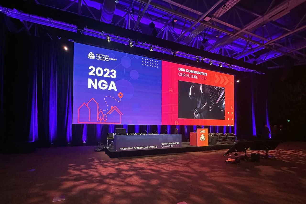 Presentation content on the wide digital screen at the 2023 NGA conference.