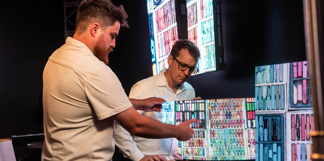 Two colleagues discussing content on a digital display.