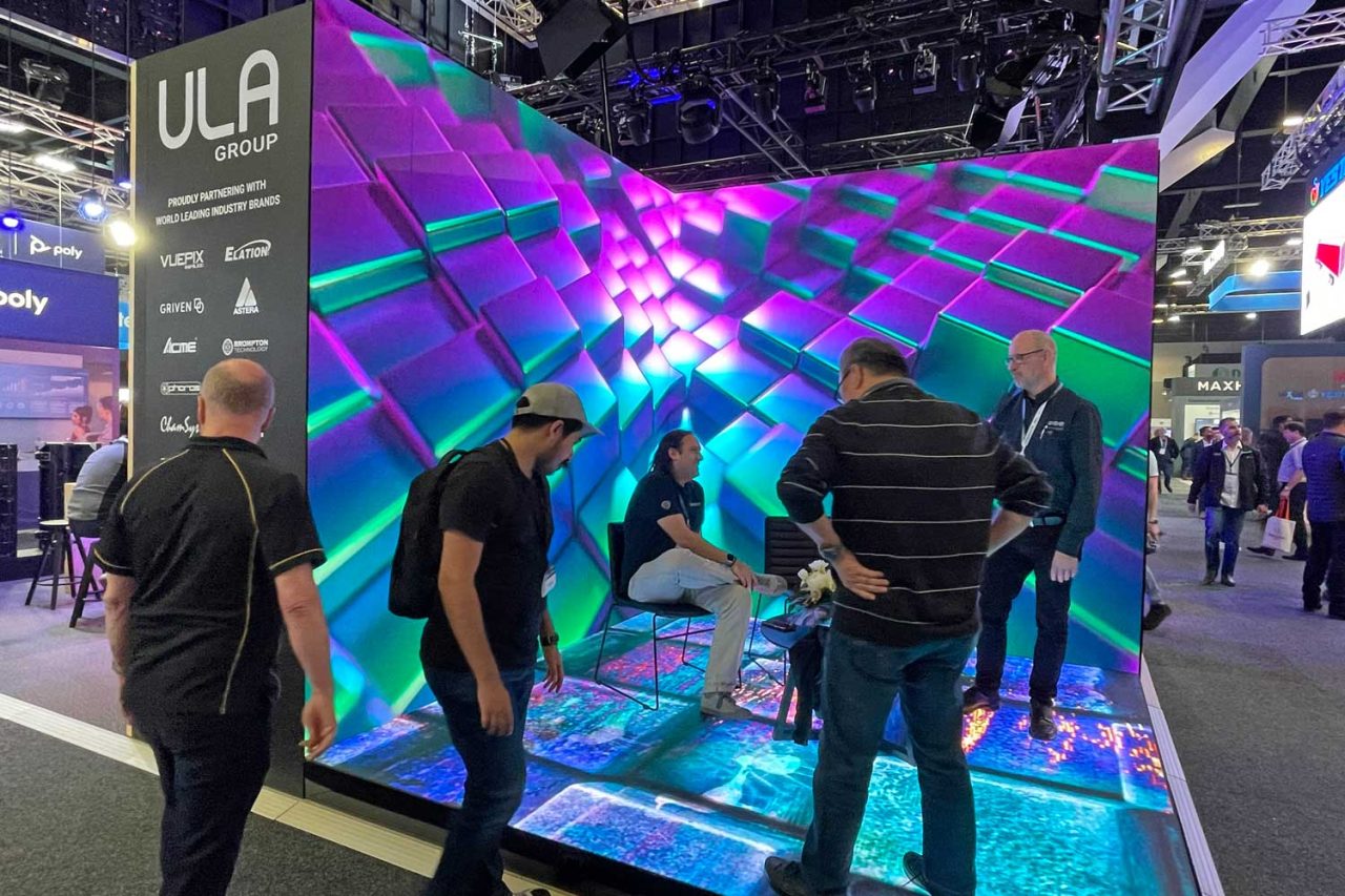 Visitors inside a colourful digital wall and floor display at Integrate 2023.
