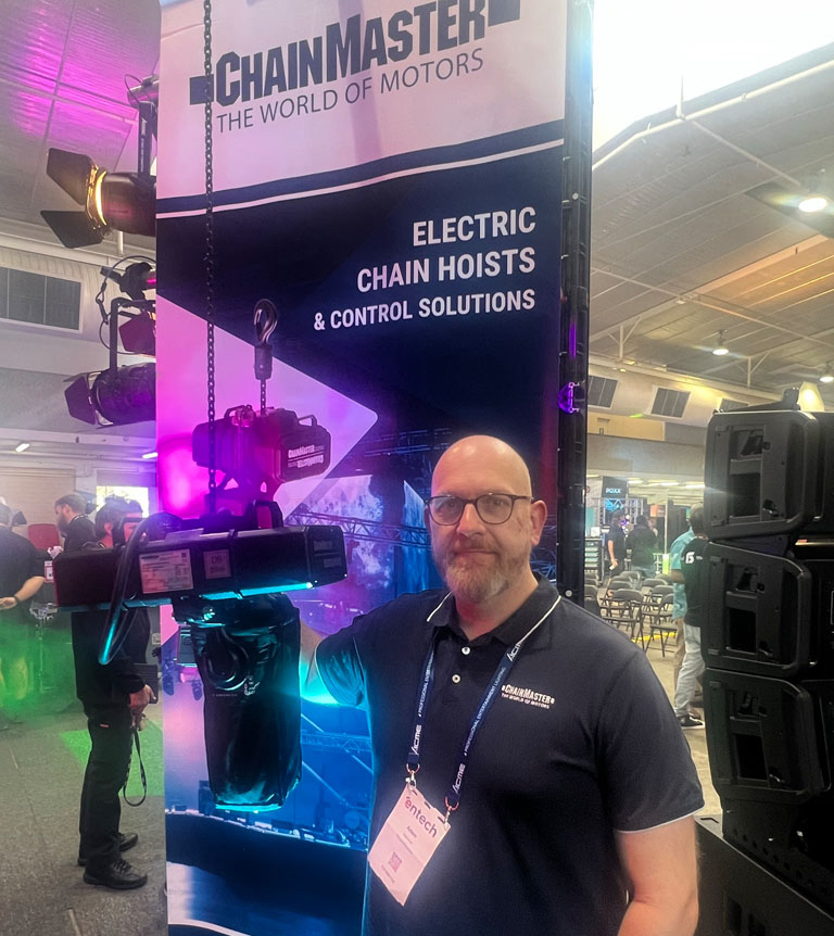 Adam Beaumont seated at a Chainmaster exhibition stand.