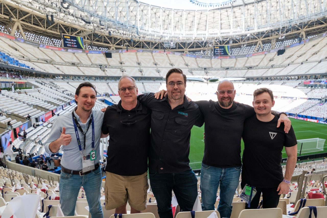 Five members of the production crew posing inside the stadium for the Asian Cup opening ceremony.