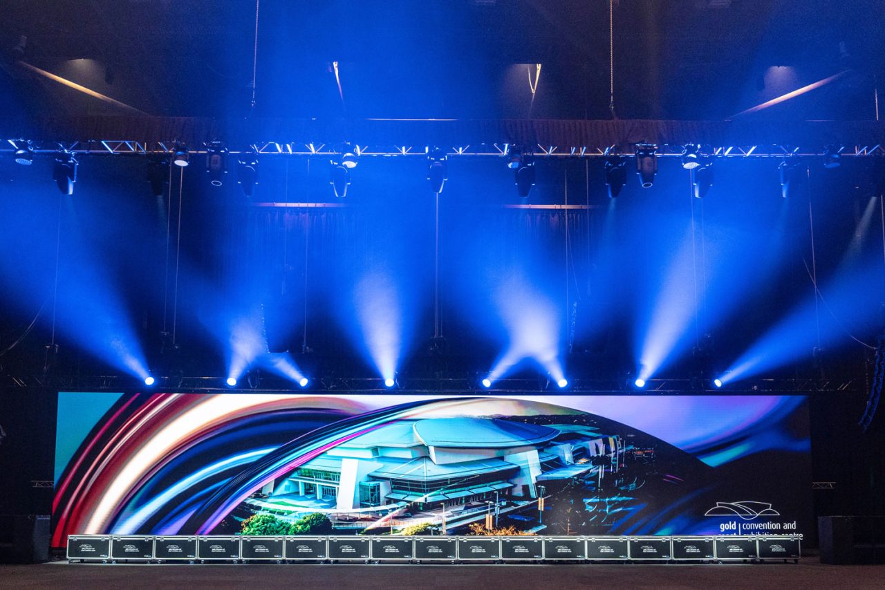 White lighting beams above a colourful panoramic video wall at GCCEC.