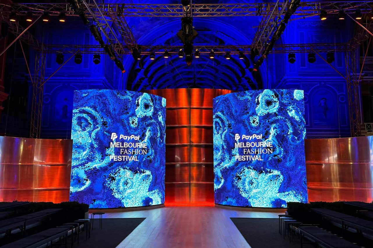 Blue abstract digital columns framing the PayPal Melbourne Fashion Festival runway.