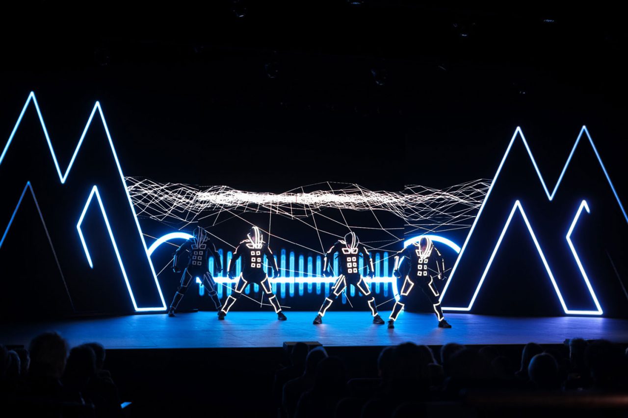 Dancers performing between illuminated geometric frames and an LED backdrop at TAUMATA 2024.
