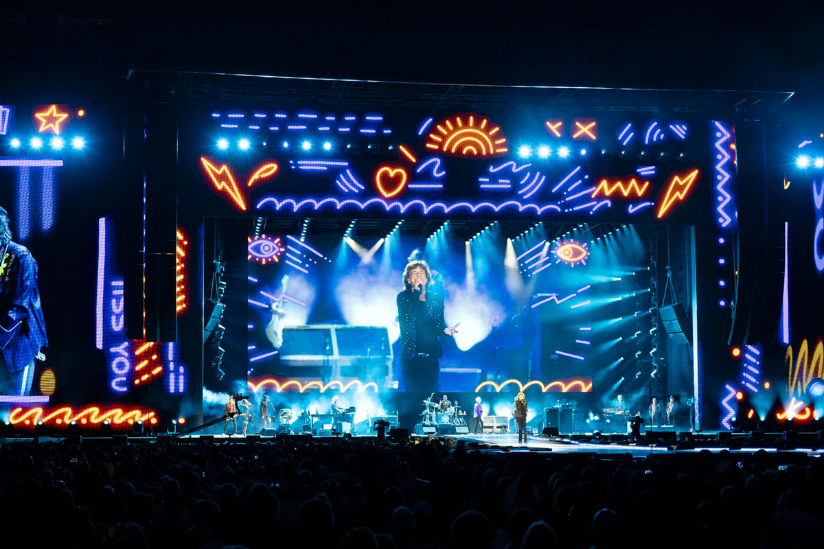 Rolling Stones stage framed by colourful graphic borders and blue beams on the Hackney Diamonds tour.