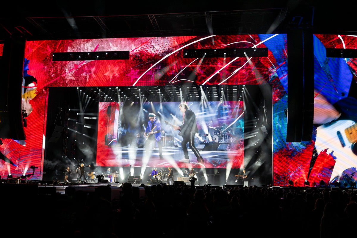Red screen graphics surrounding the Rolling Stones stage with crossing white beams.