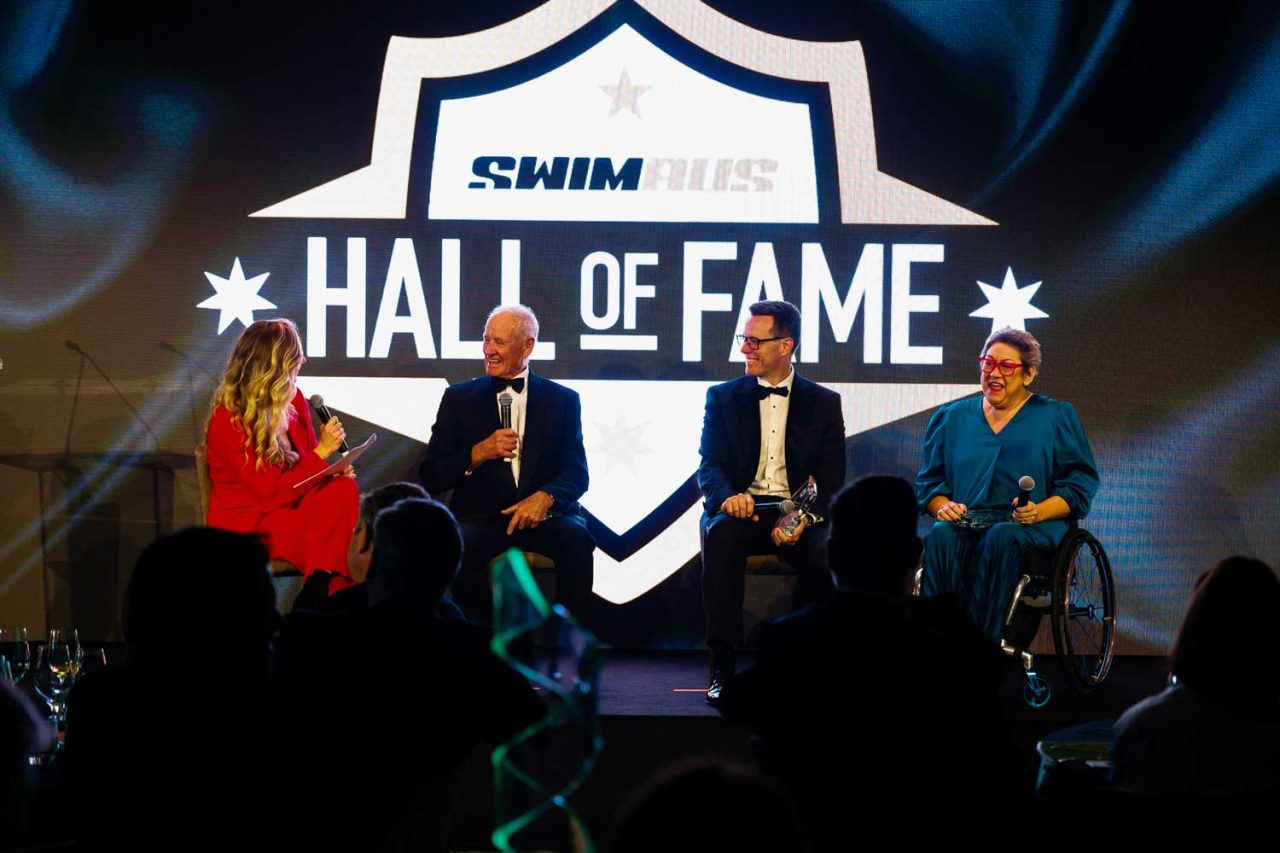 Panel seated in front of the Swim Australia Hall of Fame stage screen.