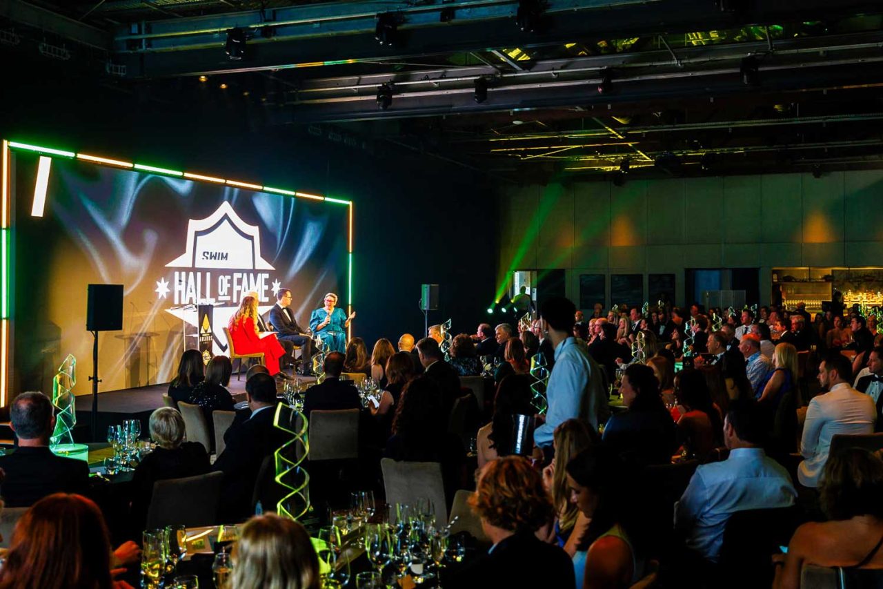 Guests facing the stage and large LED screen at the 2024 SWIMAUS Awards.