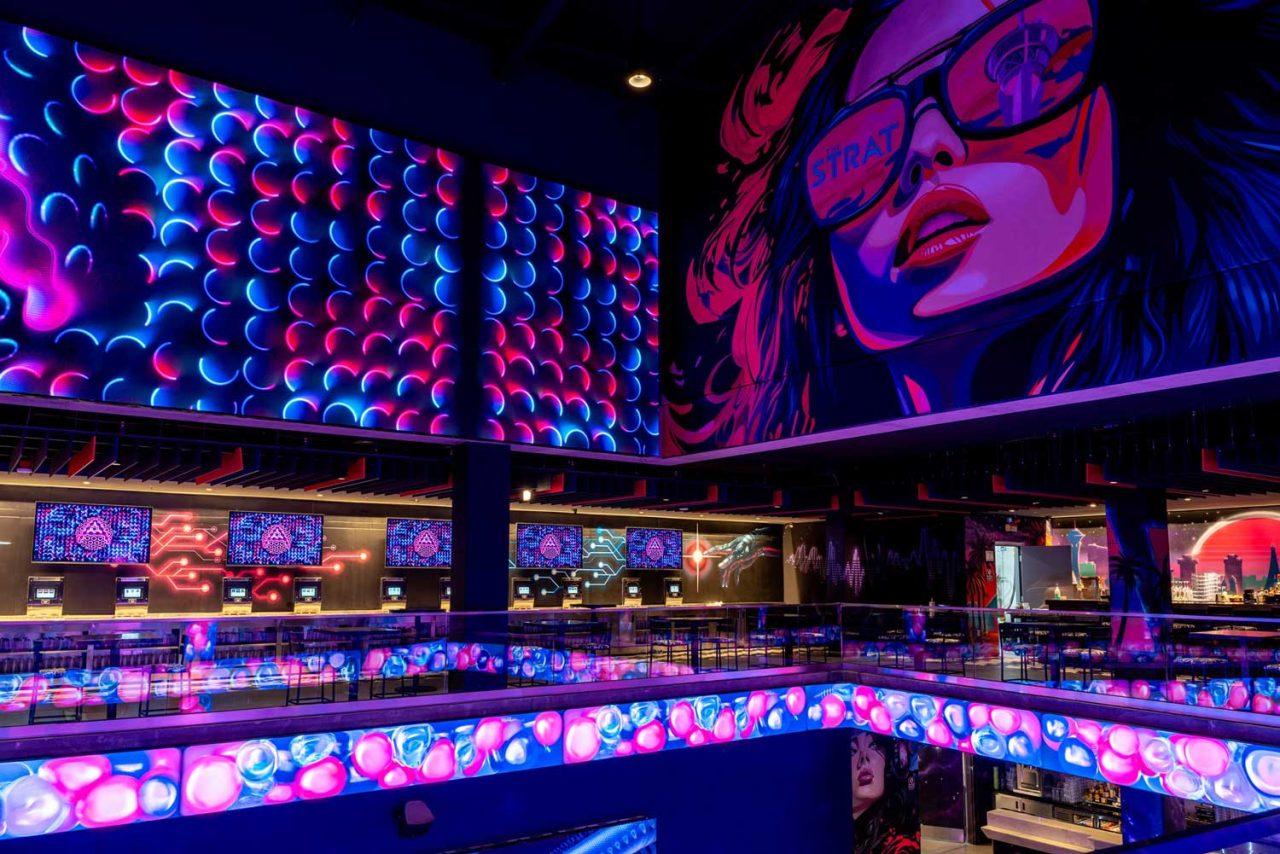 Multilevel Atomic Golf interior filled with colourful projected patterns.