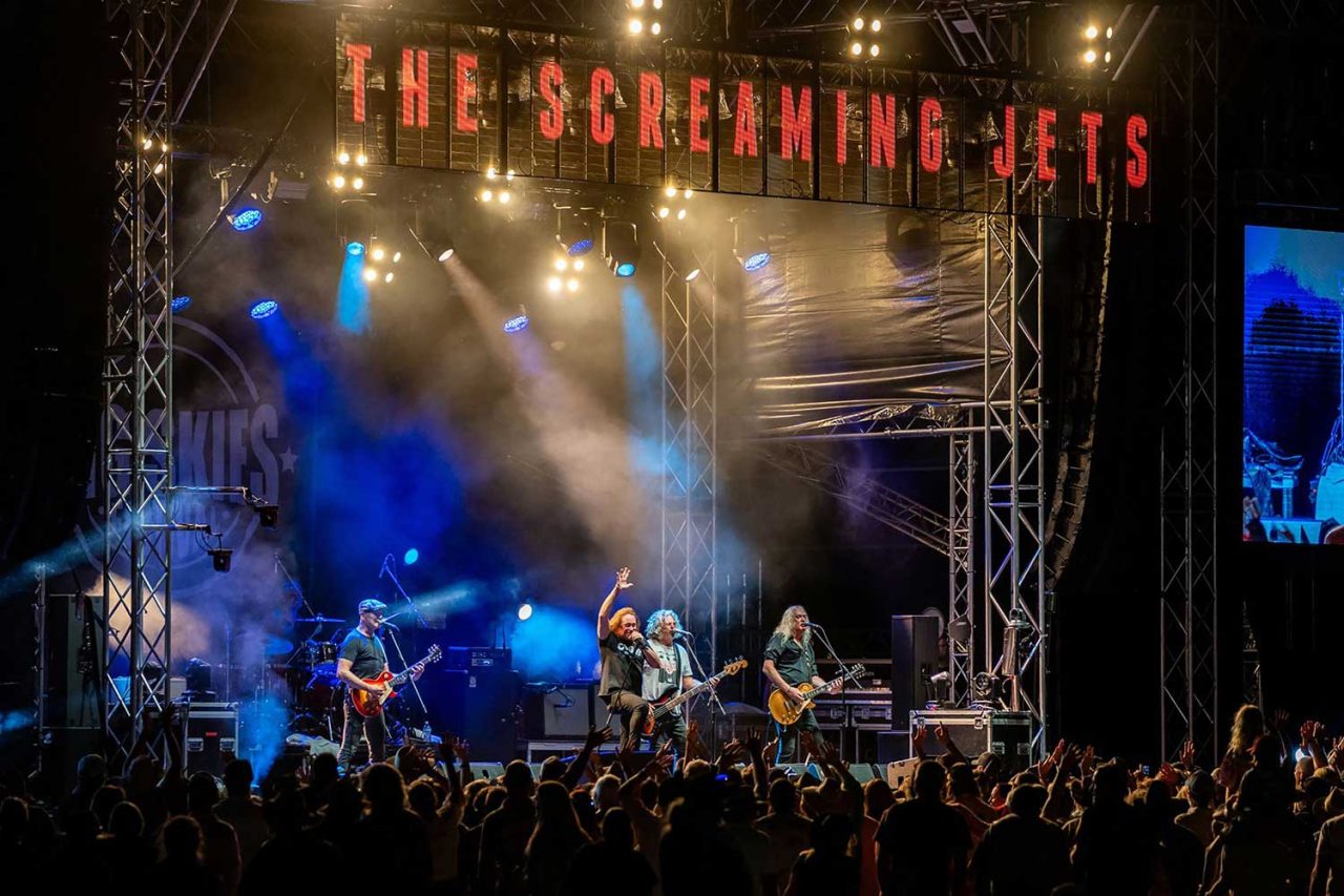 The Screaming Jets performing beneath warm beams at Big Skies Festival 2024.