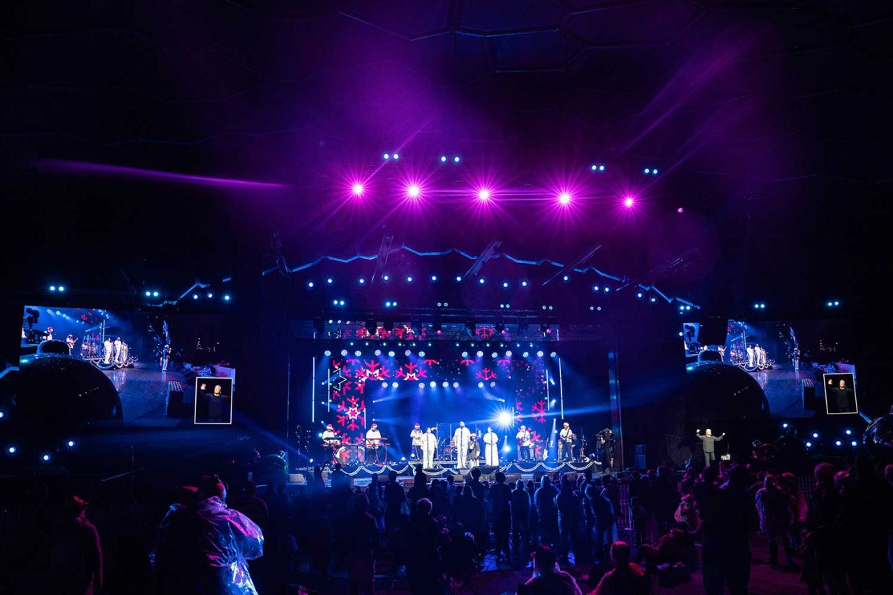 Wide view of the stage, audience and purple lighting at the 2024 Gold Coast Mayor's Carols.