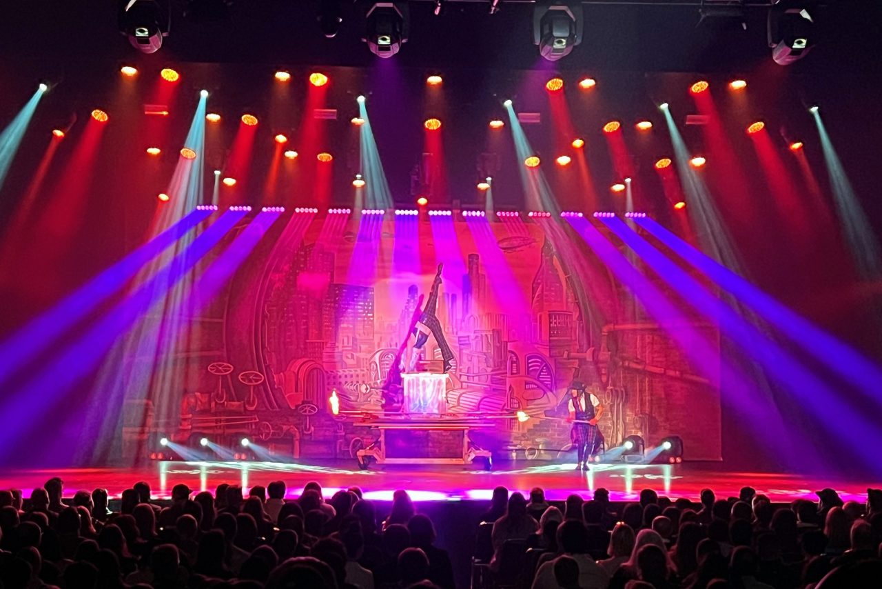Purple beams across the red stage backdrop during Cosentino's Decennium show.