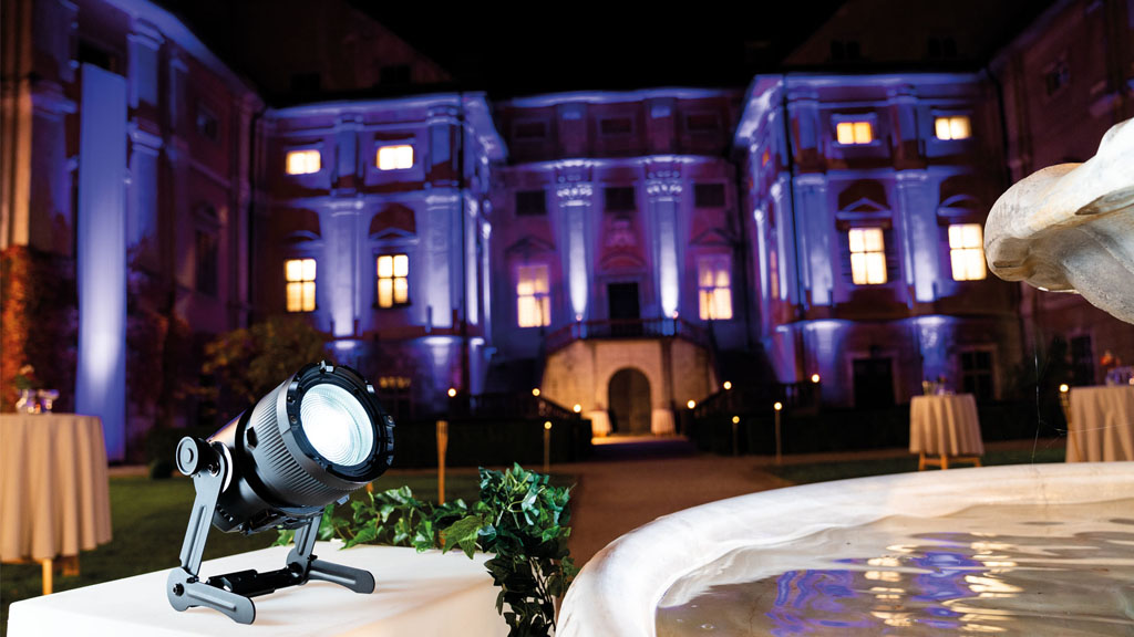 Astera QuikSpot beside a fountain illuminating a courtyard at night.