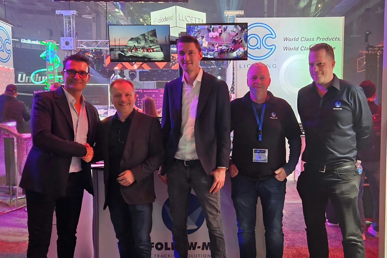 ULA Group and Follow-Me representatives posing together at an exhibition stand.