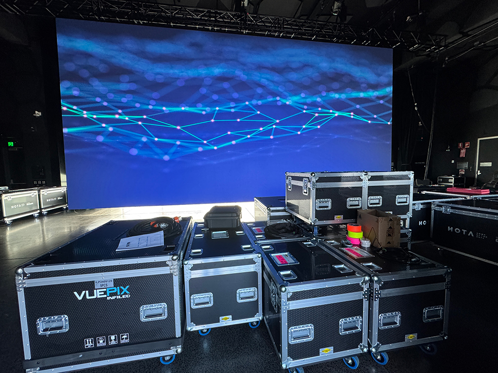 Active LED screen above VuePix and HOTA flight cases backstage.