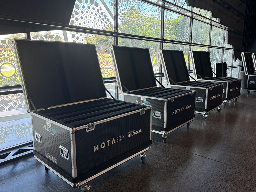 Open HOTA-branded flight cases lined up beside a window.