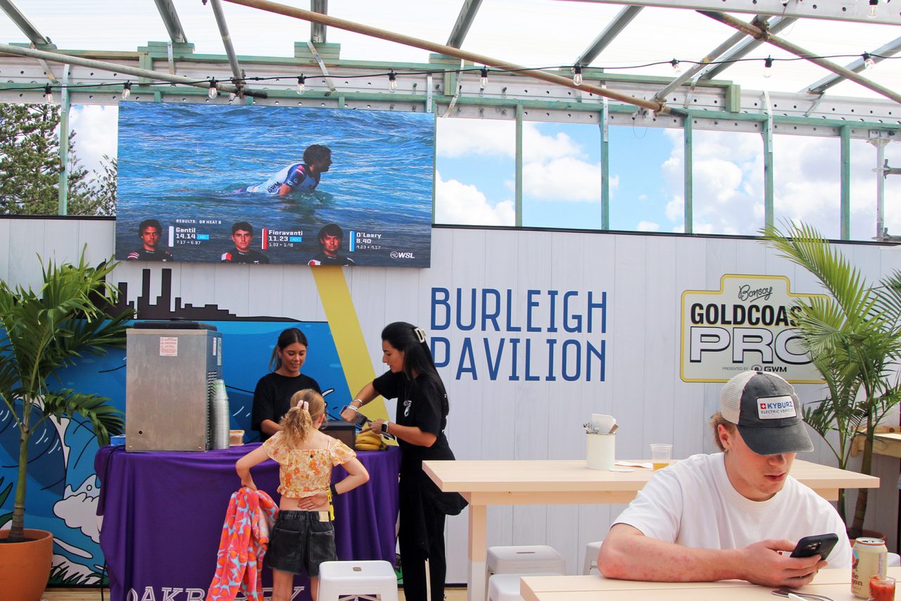 Surf coverage on a screen above guests at the Burleigh Pavilion activation during the Gold Coast Pro.