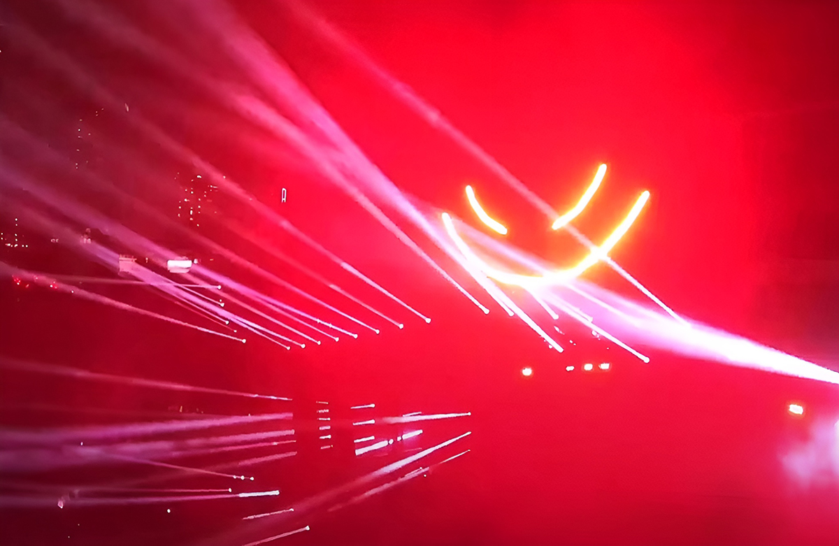 Red stage lighting with bright white beams at Ultra Miami.