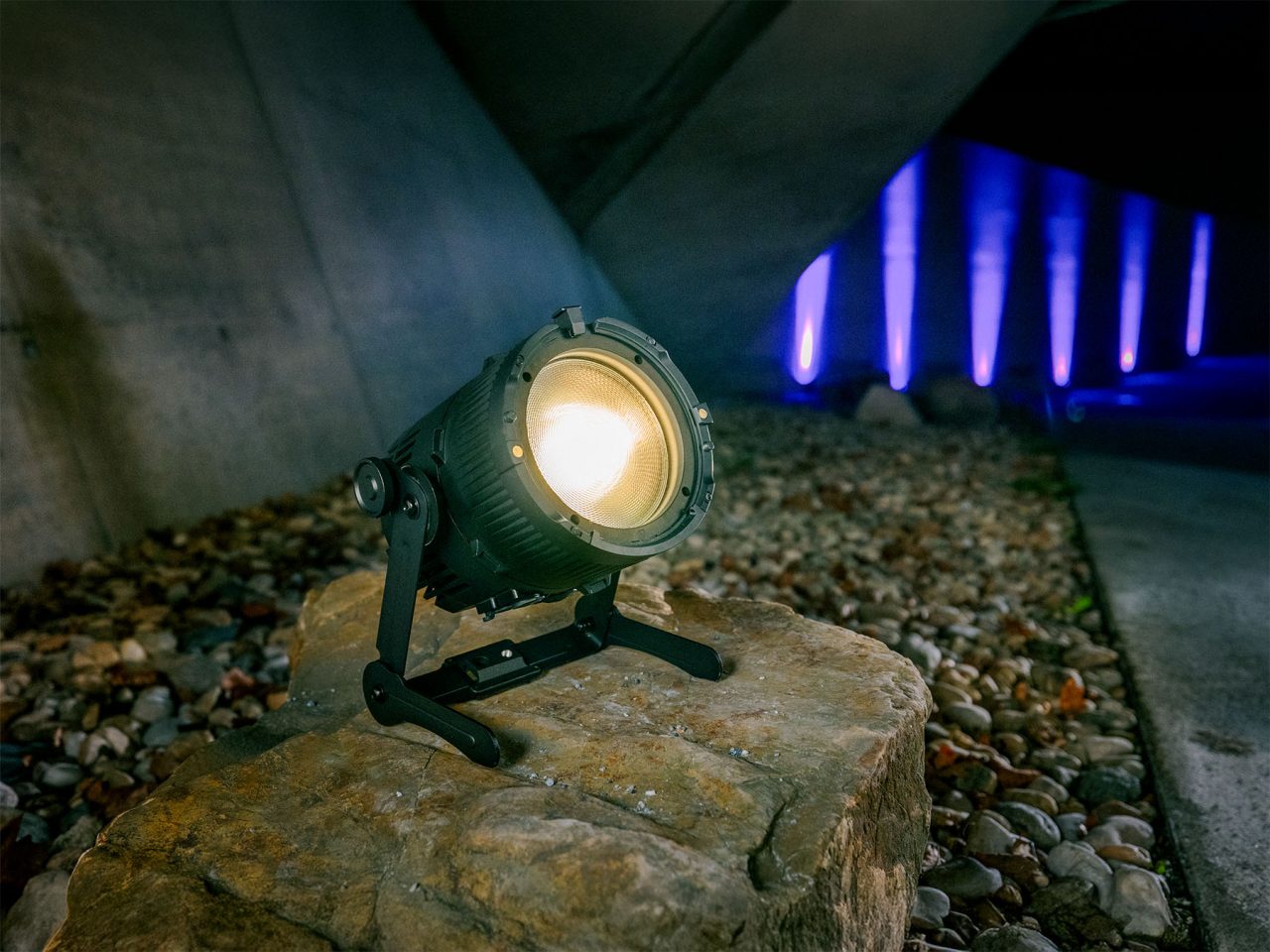 Astera QuikPunch lighting a stone surface beside blue-lit columns.
