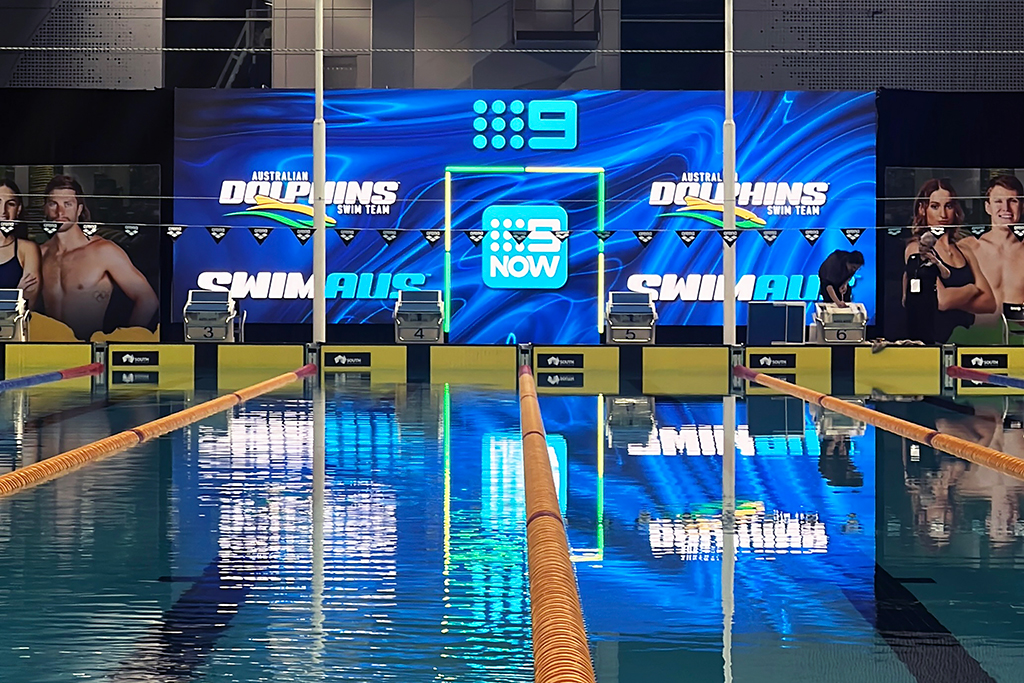 Poolside LED screen displaying broadcaster and swimming graphics at the 2025 Australian Swimming Trials.