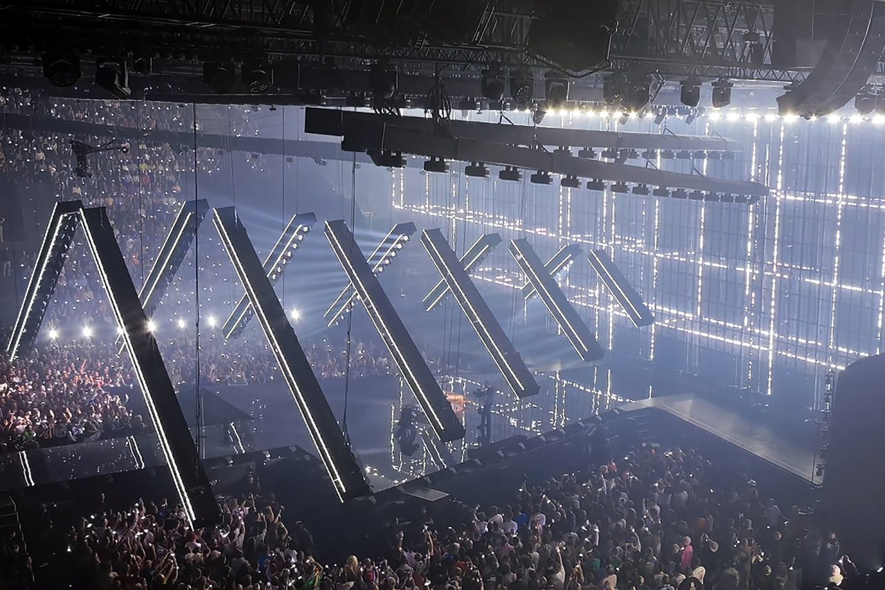 Angled lighting frames descending above the Eurovision stage and audience.