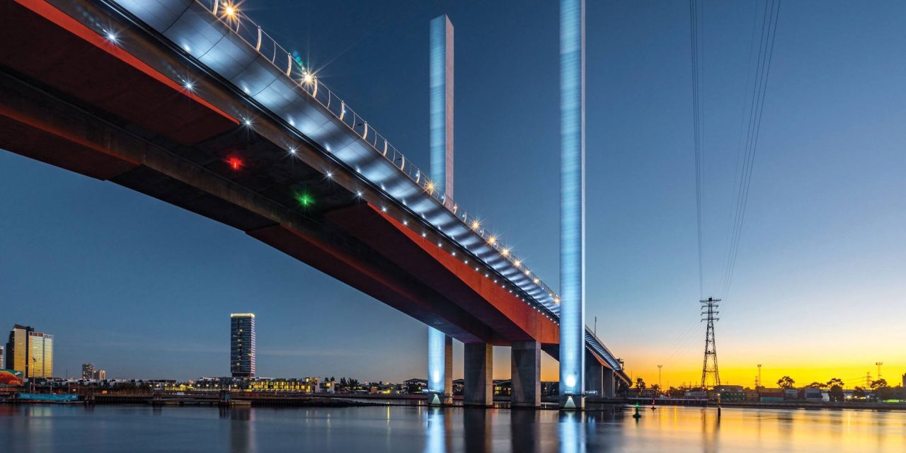 Bolte Bridge with white-lit towers above the river at dusk.