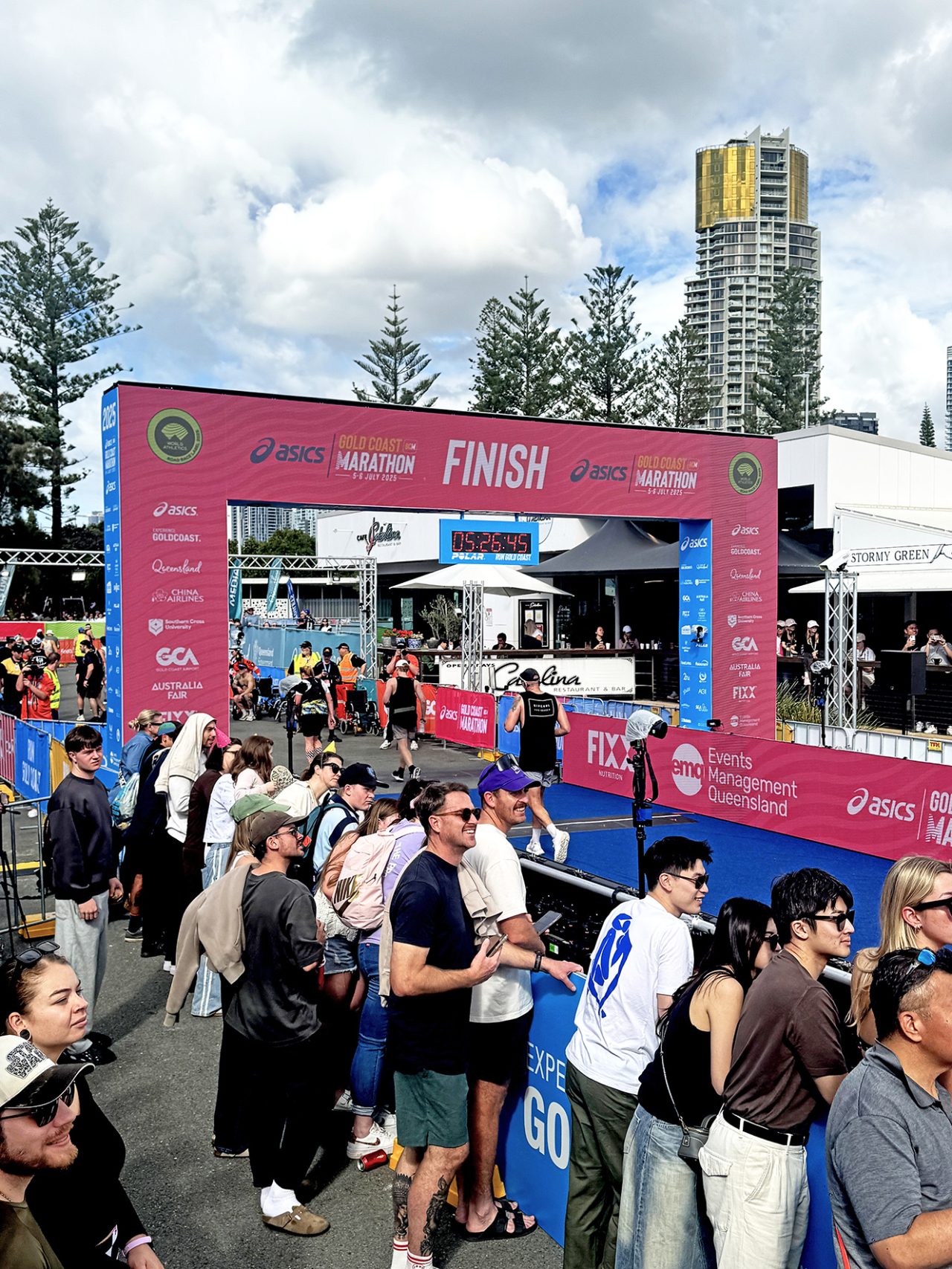 Crowds gathered around a pink finish arch and event display at the Gold Coast Marathon.