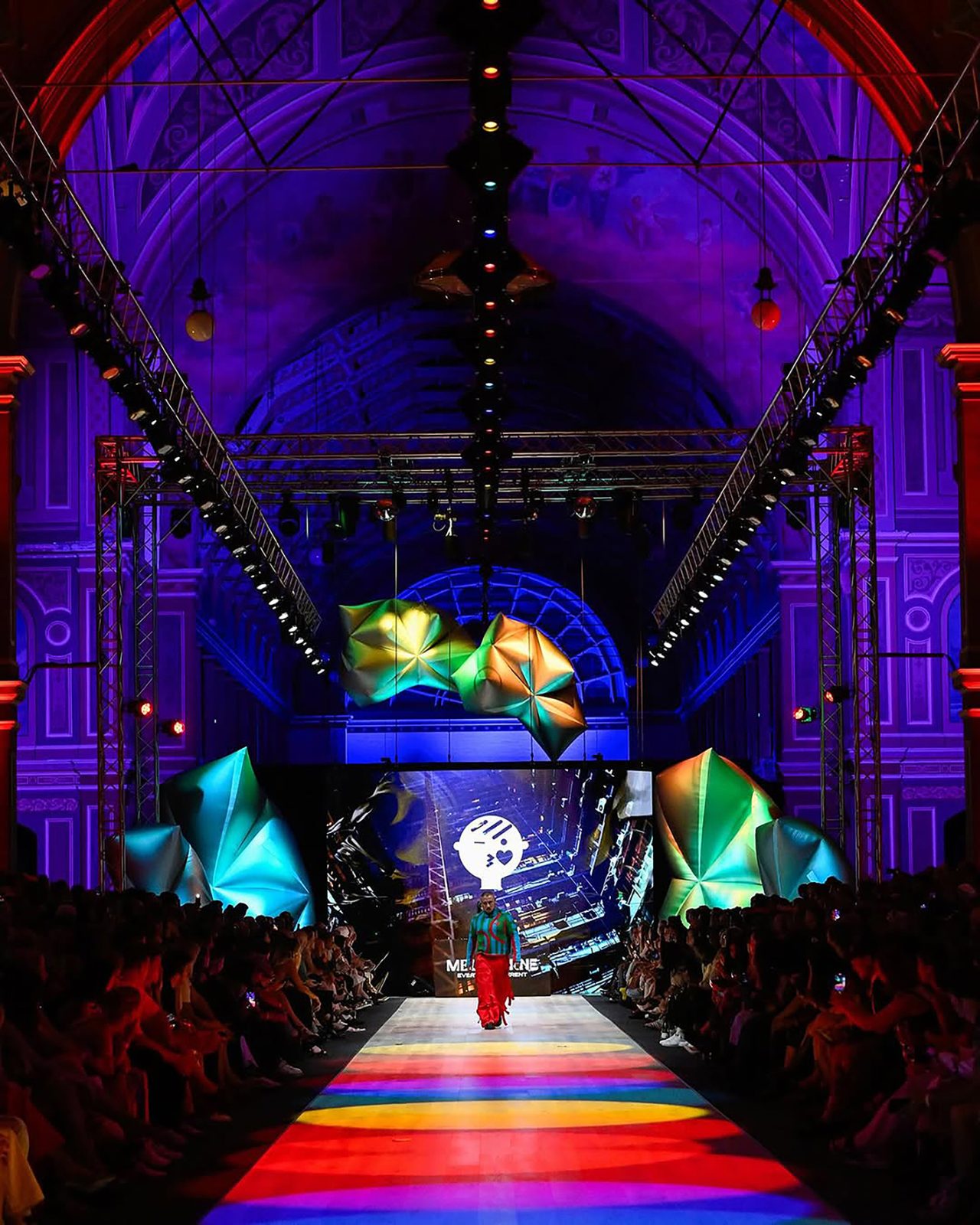 Royal Exhibition Building runway hall illuminated in purple and green for Melbourne Fashion Festival 2025.