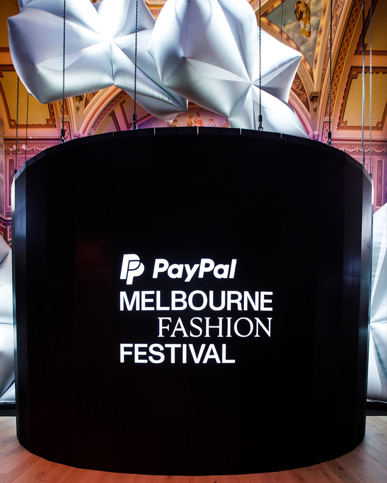 Curved digital sign displaying PayPal Melbourne Fashion Festival branding.