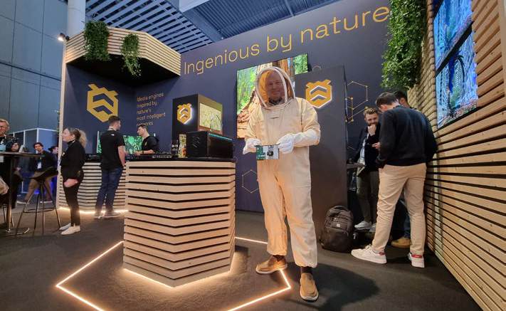 HIVE representatives at an exhibition stand with a wooden counter.