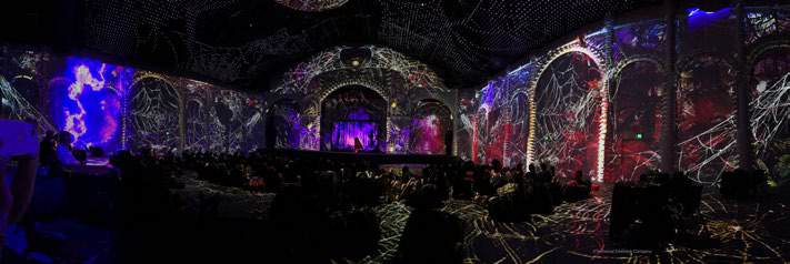 Colourful projections covering the arches and walls of an immersive exhibition.