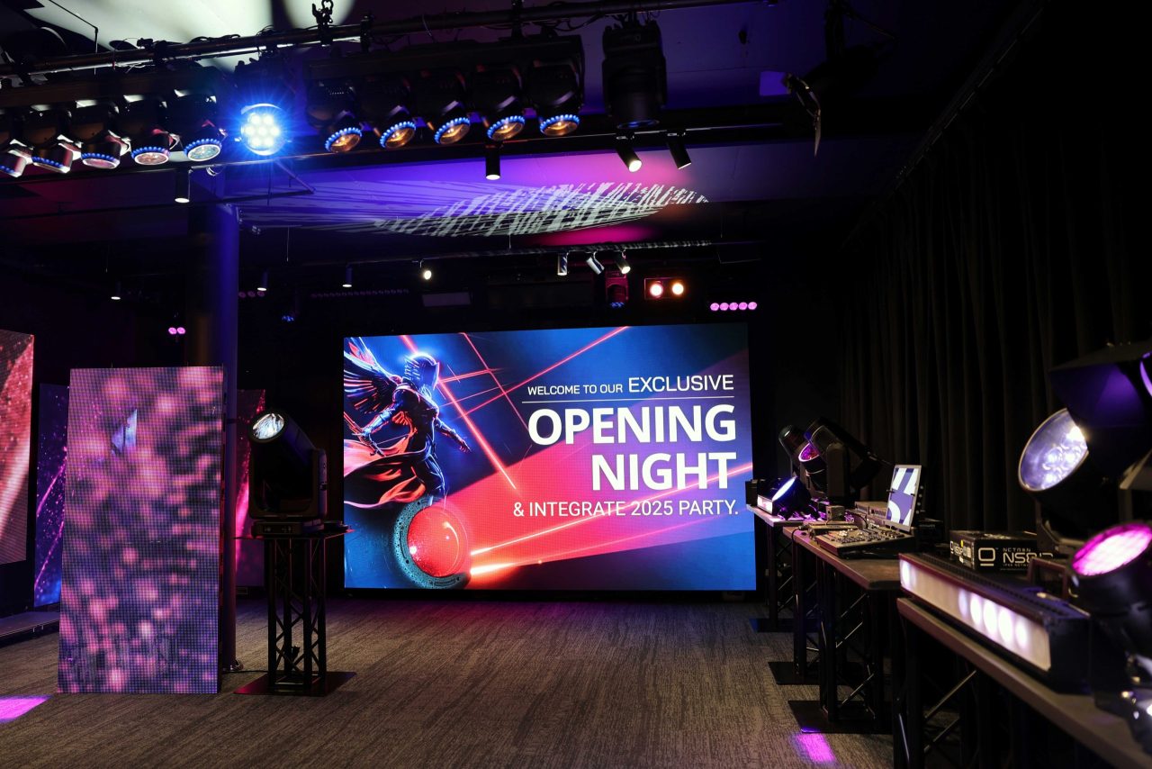 ULA Sydney showroom opening-night graphic on a large screen surrounded by lighting fixtures.