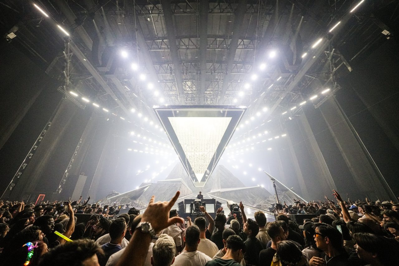 Bright white triangular screen above a cheering crowd at the E-Sports World Cup opening.