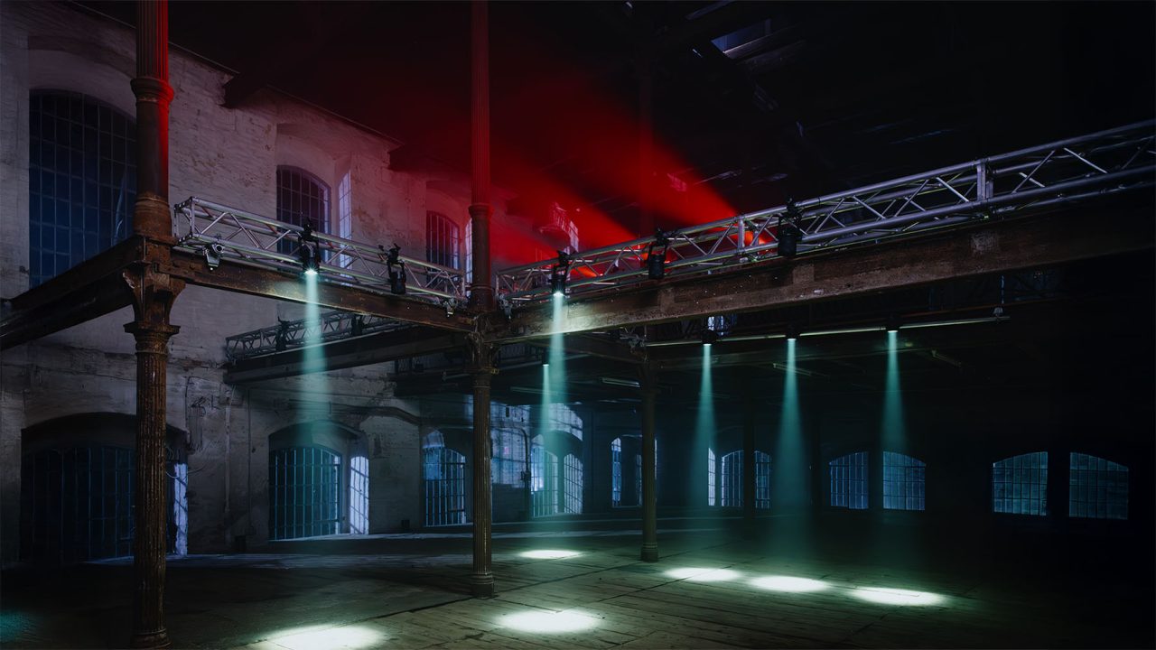 Rows of narrow white beams lighting an industrial interior.