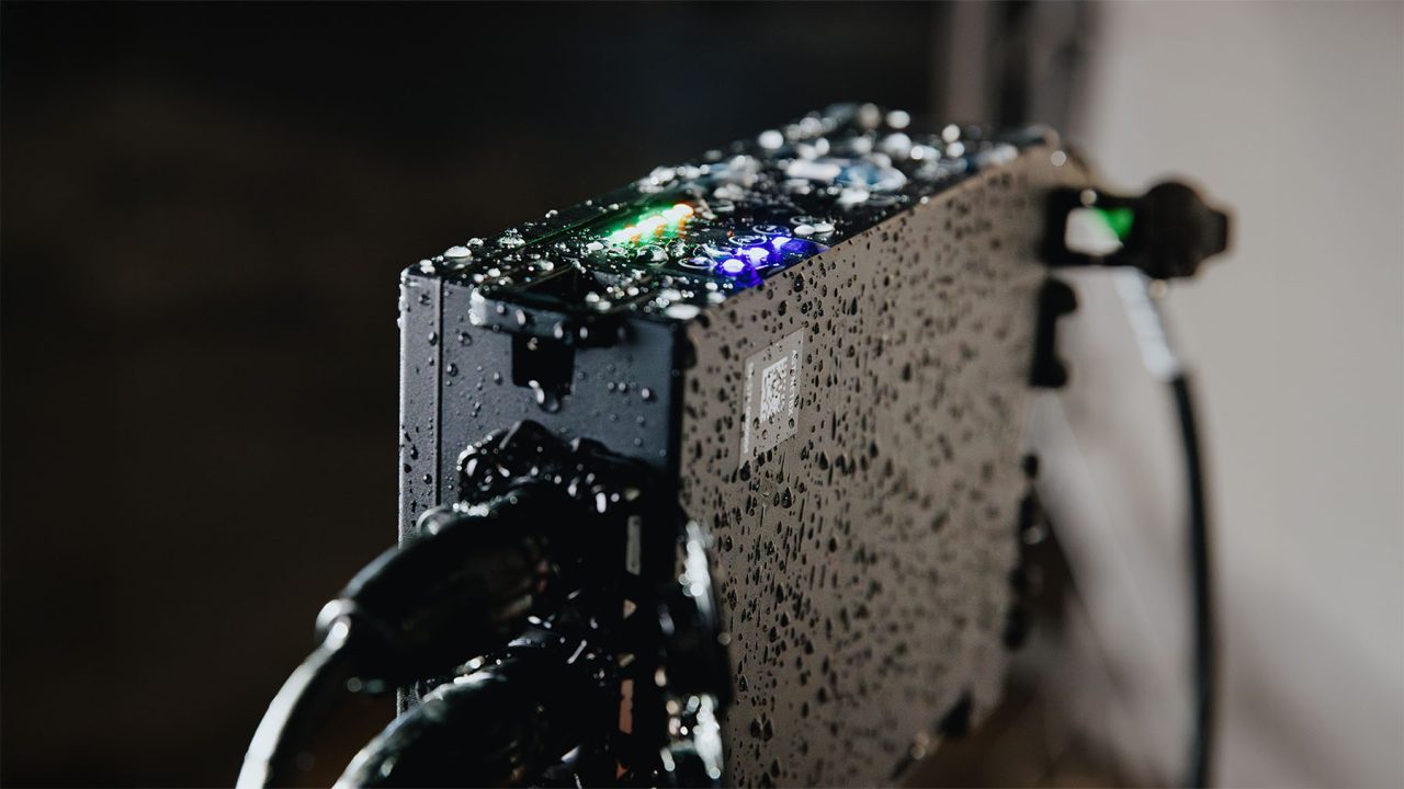 Water droplets on an Astera QuikBeam NetBox and its connected cables.