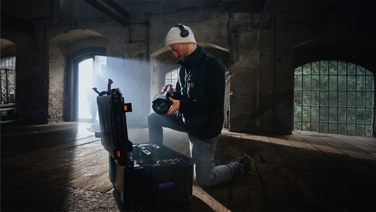 Technician preparing QuikBeam fixtures beside an open carrying case.