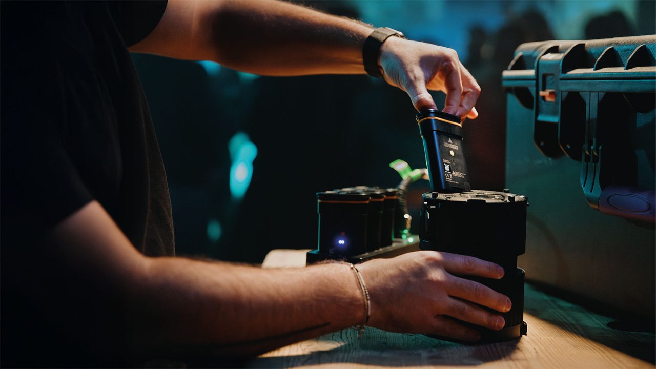 Hands inserting a QuikBrick into an Astera QuikBeam unit.