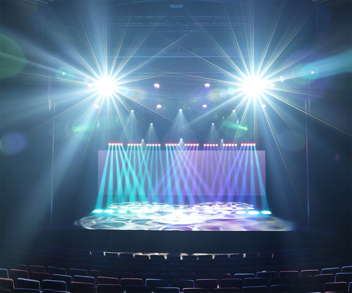 Cyan and white beams spreading across HOTA's theatre stage.