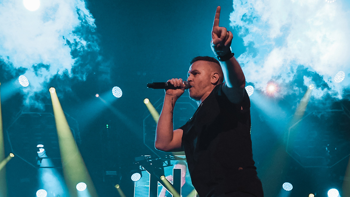 Vocalist performs beneath cloud imagery on the Hilltop Hoods stage screen.